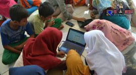 Anak-anak Desa Campor Barat tampak serius saat belajar menggunakan laptop. 