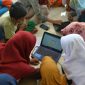 Anak-anak Desa Campor Barat tampak serius saat belajar menggunakan laptop. 