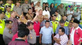 Dijaga polisi, warga terlihat berdiri di depan kantor Dinas Kesehatan Bangkalan.
