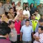 Dijaga polisi, warga terlihat berdiri di depan kantor Dinas Kesehatan Bangkalan.