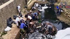 Petugas kebersihan tengah membersihkan limbah pabrik tekstil di aliran sungai Citarum, Cimahi. 