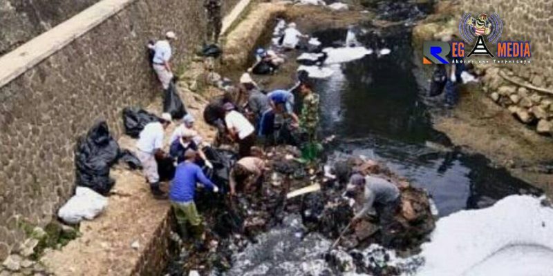 Petugas kebersihan tengah membersihkan limbah pabrik tekstil di aliran sungai Citarum, Cimahi. 