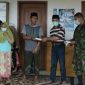 Kepala Desa Gunung Rancak (Moh. Juhar) tengah memberikan masker kepada warganya. 