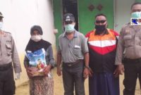 Kapolsek Robatal dan anggotanya didampingi Kades Gunung Rancak serta tokoh masyarakat saat memberikan bantuan. 