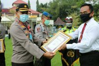 Kapolres Bangkalan (AKBP Rama Samtama Putra) tengah memberikan piagam penghargaan kepada anggotanya. 
