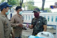 Ketua Aliansi Jurnalis Sampang (Kamaluddin) saat memberikan makser dan hand sanitizer kepada salah satu PKL. 