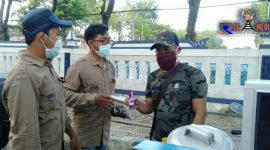 Ketua Aliansi Jurnalis Sampang (Kamaluddin) saat memberikan makser dan hand sanitizer kepada salah satu PKL. 