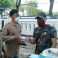 Ketua Aliansi Jurnalis Sampang (Kamaluddin) saat memberikan makser dan hand sanitizer kepada salah satu PKL. 