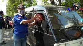 Ketua JCW Sampang (H. Moh. Tohir) tengah memberikan masker kepada pengendara mobil didepan Pasar Srimangunan, Sampang. 