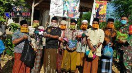 Kepala Desa Morbatoh (H. Moh. Sobrun) saat memberikan masker kepada warganya. 