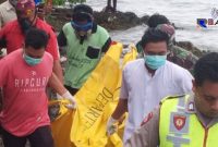 Petugas saat mengevakuasi mayat perempuan yang ditemukan dibibir pantai Desa Bira Barat, Sampang. 