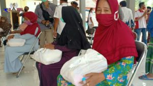 Salah satu warga Kecamatan Tanjung Bumi saat menerima bantuan sembako jaring pengaman sosial