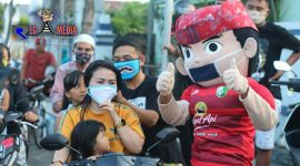 Salah satu suporter Persesa dan Si Joyo tengah membagikan masker kepada beberapa pengguna jalan. 