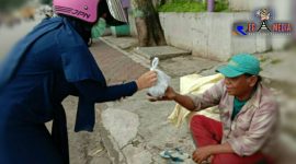 Pendistribusian nasi bungkus dari dapur umum kepada masyarakat yang membutuhkan. 