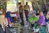 Terlihat sejumlah polisi dan korban banjir tengah berada ditempat pengungsian. 