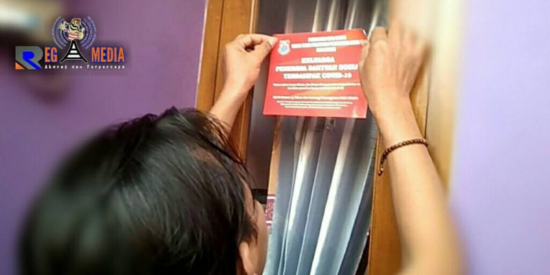 Warga menempeli rumahnya dengan masker bagi yang menerima bansos Covid-19.