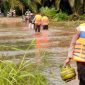 Salah satu personel brimob terlihat tengah membantu membawakan peralatan dapur warga. 