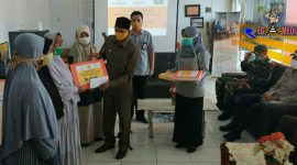 Plt Bupati Aceh Selatan (Tgk Amran) saat memberikan Bantuan Sosial Tunai (BST)  secara simbolis kepada warga. 