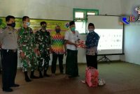 Kepala Desa Gunung Kesan (H. Abdul Bahri) didampingi Forkopimcam secara simbolis memberikan masker kepada perwakilan warga.