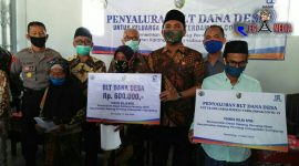 Kepala Desa Karang Penang Oloh (Remin) saat menyerahkan bantuan BLT DD secara simbolis kepada perwakilan warga didampingi Forkopimcam Karang Penang. 