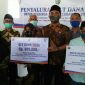Kepala Desa Karang Penang Oloh (Remin) saat menyerahkan bantuan BLT DD secara simbolis kepada perwakilan warga didampingi Forkopimcam Karang Penang. 