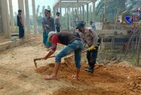 Terlihat sejumlah personel brimob tengah bergotong royong bersama warga.