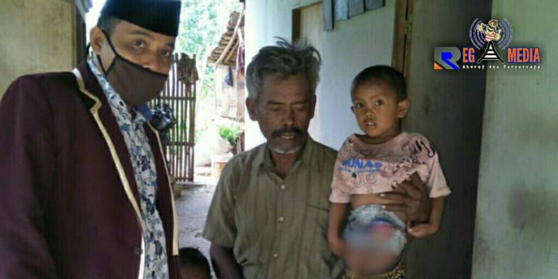 M. Fahri, bocah tanpa anus saat berada disanding ayahnya. 