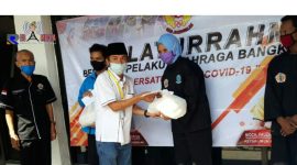 Ketua KONI Bangkalan (Fauzan Jakfar) secara simbolis memberikan bantuan paket sembako kepada perwakilan atlet pencak silat  