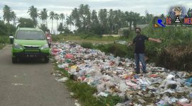 Terlihat sampah bertumpukan dan berserakan di pinggir jalan. 