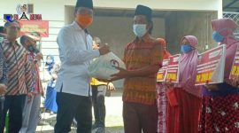 Bupati Bangkalan (R. Abdul Latif Amin Imron) secara simbolis memberikan bantuan sembako kepada Kepala Desa Dakiring (Abd. Rahman).
