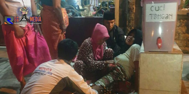 Beberapa warga tengah membantu seorang wanita yang melahirkan didepan pagar rumah bidan di Desa Ketapang Barat, Sampang. 