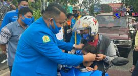 Ketua DPD KNPI Provinsi Aceh (Wahyu Saputra) saat membagikan masker kepada seorang anak pengendara motor. 