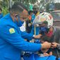 Ketua DPD KNPI Provinsi Aceh (Wahyu Saputra) saat membagikan masker kepada seorang anak pengendara motor. 