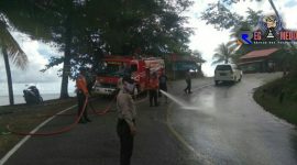 Terlihat mobil pemadam kebakaran dari BPBD Aceh Selatan melakukan pembersihan ruas jalan dari tumpahan minyak.