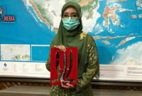 Isteri Plt. Gubernur Aceh Dyah Erti Idawati menunjukkan Rencong Batu. 