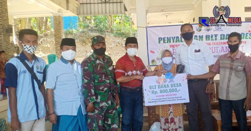 Kades Gunung Rancak Mohammad Juhar (kaos merah) saat menyerahkan BLT DD kepada warga penerima disaksikan Forkopimcam.
