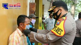 Kapolres Bangkalan (AKBP Rama Samtama Putra) saat memakaikan masker pada warga.