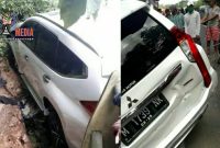 Warga mencoba mengevakuasi mobil yang nyaris nyungsep ke sungai. 