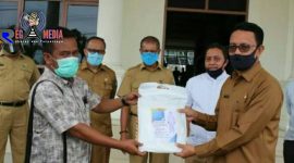 Sekda Aceh Selatan (H. Nasjuddin) saat menerima bantuan APD dari dua pengusaha yang diwakilkan tokoh masyarakat. 