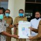 Sekda Aceh Selatan (H. Nasjuddin) saat menerima bantuan APD dari dua pengusaha yang diwakilkan tokoh masyarakat. 
