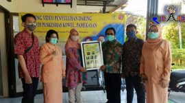 Ketua Kegiatan Pengabdian Kepada Masyarakat UTM (Dinda Rizki Tiara) saat menyerahkan video penyuluhan tentang covid-19 kepihak Puskesmas Kowel, Pamekasan.