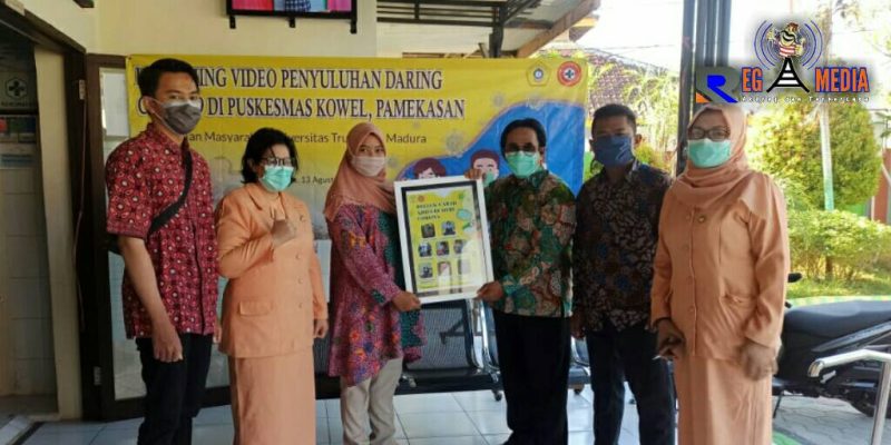 Ketua Kegiatan Pengabdian Kepada Masyarakat UTM (Dinda Rizki Tiara) saat menyerahkan video penyuluhan tentang covid-19 kepihak Puskesmas Kowel, Pamekasan.