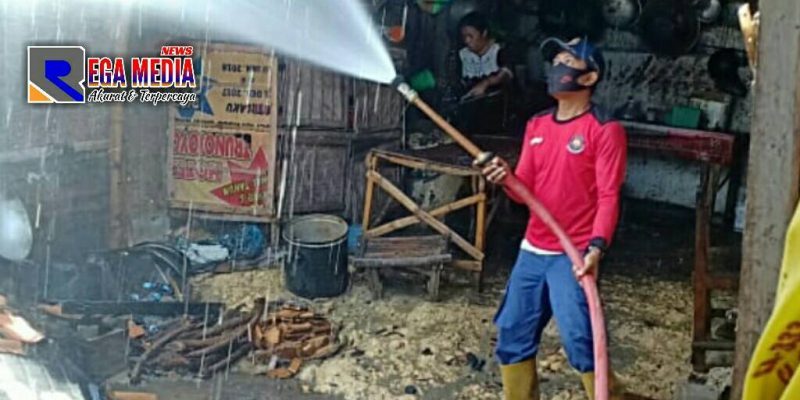 Petugas pemadam kebakaran mencoba memadamkan api yang menjalar ke atap dapur.
