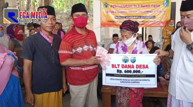 Kepala Desa Gunung Rancak Mohammad Juhar (kaos merah) saat menyalurkan BLT DD kepada warga penerima.