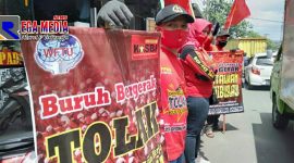 Para buruh di Kota Cimahi melakukan aksi penolakan di sepanjang jalan kota dengan membentangkan atribut penolakan.