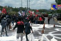 Gabungan aktivis dari mahasiswa saat melakukan aksi blokade di akses masuk jalan tol Suramadu.