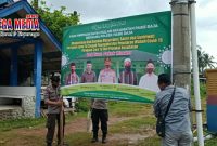 Anggota Polsek Pasie Raja terlihat tengah memasang baliho bertuliskan kalimat imbauan prokes.