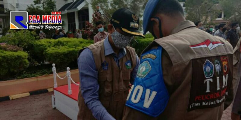 Bupati Aceh Selatan (Tgk Amran) tengah mengenakan rompi kepada Tim Peucrok.