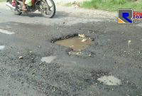 Kondisi kubangan air di jalan berlubang di lintas jalan raya Sampang-Ketapang.