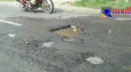 Kondisi kubangan air di jalan berlubang di lintas jalan raya Sampang-Ketapang.